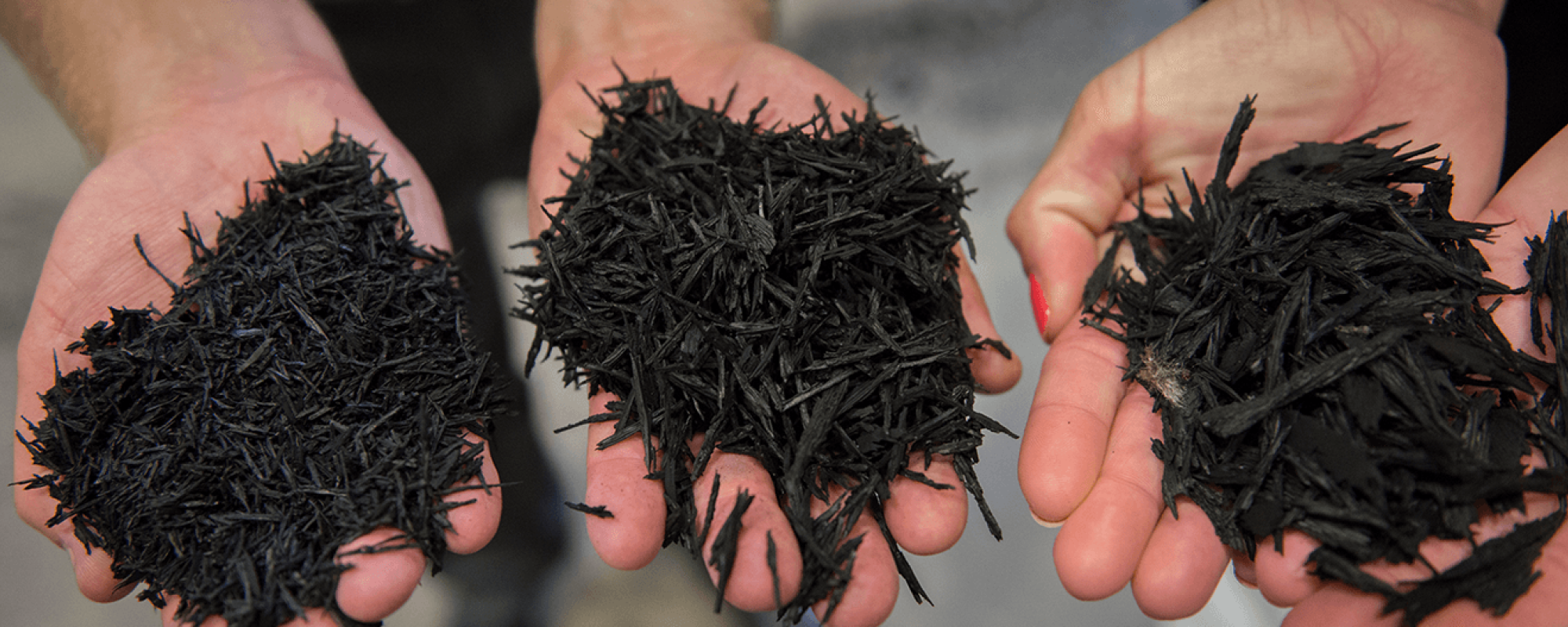 three hands holding shredded tires